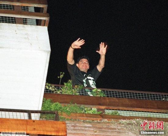 资料图：1997年10月30日晚，马拉多纳在布宜诺斯艾利斯公寓的阳台上向球迷和记者挥手致意。此前他在接受一个电视节目的电话采访时宣布退役。